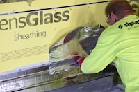Worker in Siplast apparel applying a self-adhered flashing membrane to act as an air barrier.